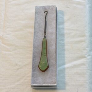 Vintage Button Hook Tool color green on one side brown on the other side.